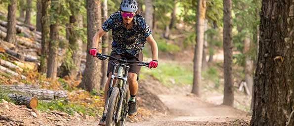 White Pine Touring women's mountain biking instructor riding on a trail in Park City, UT