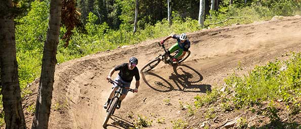 White Pine Touring women's mountain biking instructor riding on a trail in Park City, UT