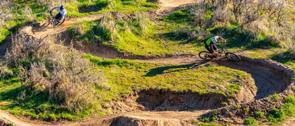 Two mountain bikers ride a winding trail in Park City, UT